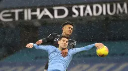 Bek Manchester City, John Stones, berebut bola dengan striker Aston Villa, Ollie Watkins, pada laga lanjutan Liga Inggris di Etihad Stadium, Kamis (21/1/2021) dini hari WIB. Manchester City menang 2-0 atas Aston Villa. (AFP/Clive Brunskill/pool)