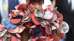 Penampilan Rihanna pada acara penggalangan dana Met Gala 2017 di Metropolitan Museum of Art, New York, Senin (1/5). Rihanna mengenakan busana dengan aksen bunga di sekelilingnya, yang bahannya saling bertumpuk seperti kelopak bunga. (ANGELA WEISS/AFP)