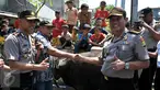 Inspektur Pengawas Daerah Kombes Polda Metro Jaya Didit Prabowo (kanan) bersama Kepala Polisi Resort Jakarta Pusat Hendro Pandowo (kiri) menyerahkan dua ekor sapi kurban di kawasan Johar Baru, Jakarta, Rabu (23/9/2015). (Liputan6.com/Gempur M Surya)