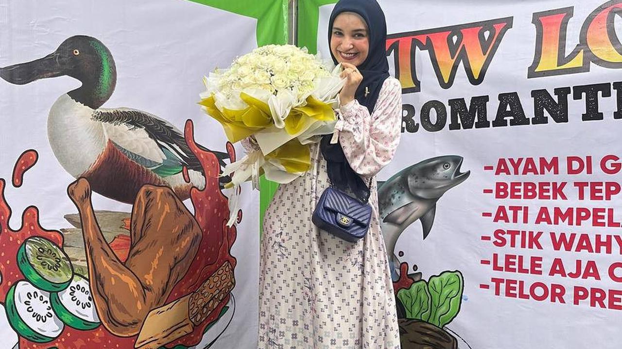 Shireen tersenyum manis saat berpose dengan buket bunga dari Wisnu. Pesona ibu tiga anak ini memancar dalam senyuman dan kebahagiaannya.
