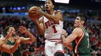 Derrick Rose melakukan jump shot diantara pengawalan ketat pemain Bucks (Jerry Lai-USA TODAY Sports)