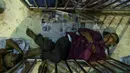 Calon pembeli tidur saat mengantre demi mendapatkan tiket mudik lebaran di Stasiun Kereta Kamalapur, Dhaka, Minggu (3/7). Pemudik Bangladesh rela antre berjam-jam dan bahkan menunggu jauh hari sebelum pembukaan loket tiket. (AFP PHOTO/MUNIR UZ ZAMAN)