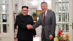 Perdana Menteri Singapura, Lee Hsien Loong bejabat tangan sambut kedatangan pemimpin Korea Utara Kim Jong-un di Istana Kepresidenan Singapura, Minggu (10/6). Kim Jong-un dan Donald Trump akan bertemu 12 Juni. (AFP Photo/HO/Kementerian Kominfo Singapura)