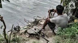 Aktivitas warga saat memancing di waduk kawasan Sungai Bambu, Tanjung Priok, Jakarta, Minggu (17/1/2021). Waduk buatan yang tepat berada di bawah Jalan Tol Pelabuhan tersebut menjadi wisata alternatif menghabiskan akhir pekan tanpa mengeluarkan biaya atau gratis. (merdeka.com/Iqbal S. Nugroho)