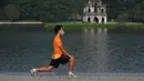 Seorang pria berolahraga di sepanjang danau Hoan Kiem setelah otoritas kota mengizinkan kegiatan olahraga menyusul pelonggaran pembatasan Covid-19, Selasa (28/9/2021). Sejauh ini, 94 persen dari populasi orang dewasa Hanoi telah menerima satu suntikan vaksin COVID-19. (Nhac NGUYEN/AFP)