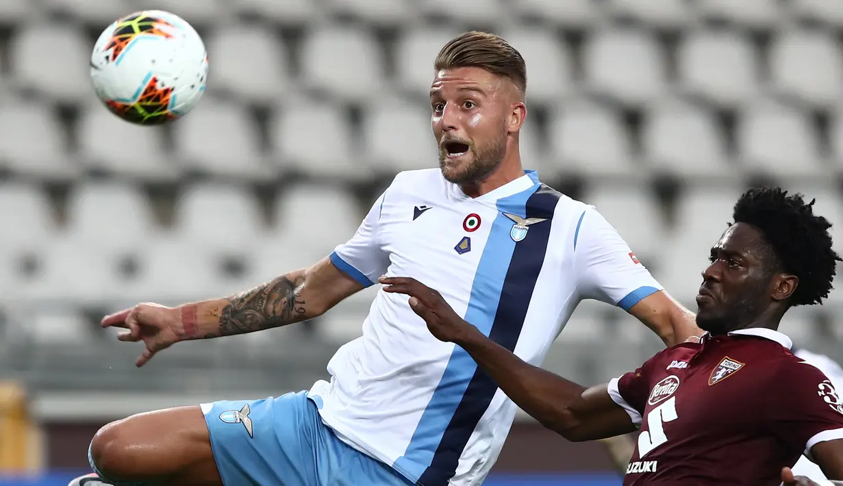 Gelandang Lazio, Sergej Milinkovic, berebut bola dengan pemain Torino pada laga lanjutan Serie A pekan ke-29 di Stadion Olimpico Grande Torino, Rabu (1/7/2020) dini hari WIB. Lazio menang 2-1 atas Torino. (AFP/Isabella Bonotto)