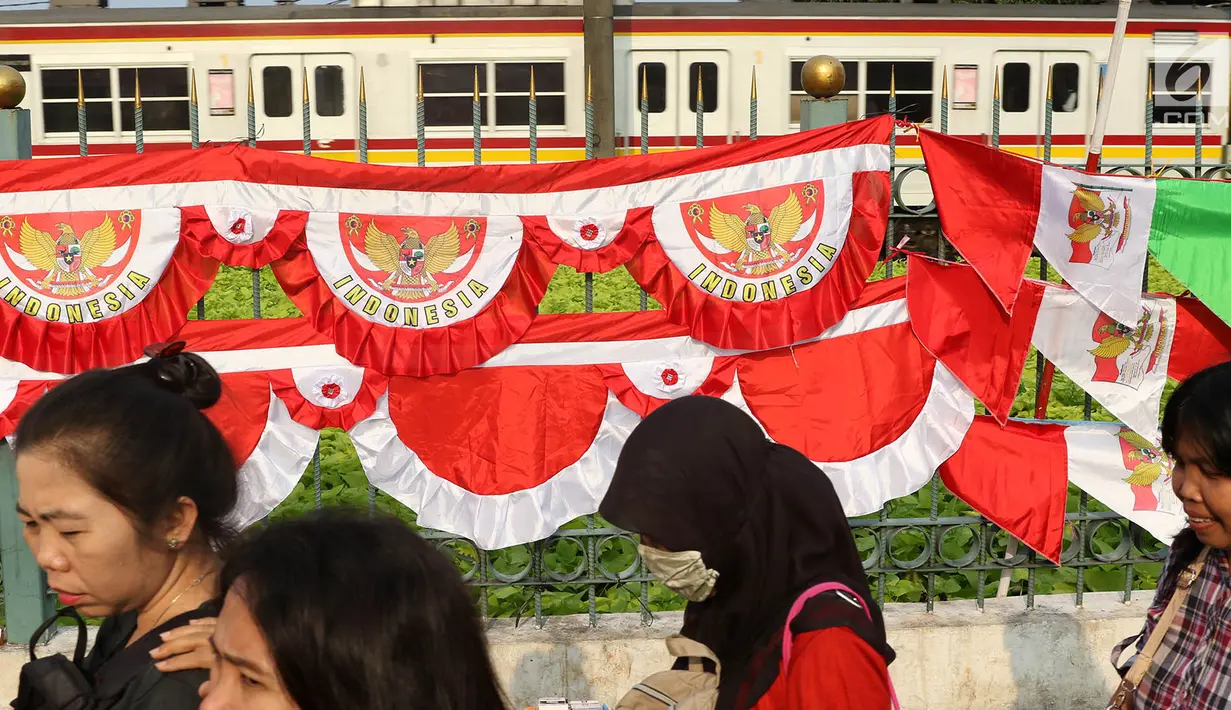 Warga melintas di depan bendera dan aksesori kemerdekaan RI, Jakarta Selatan, Selasa (1/8). Penjualan bendera serta aksesori kemerdekaan ditawarkan dengan harga bervariasi, mulai Rp10ribu hingga Rp250ribu. (Liputan6.com/Immanuel Antonius)