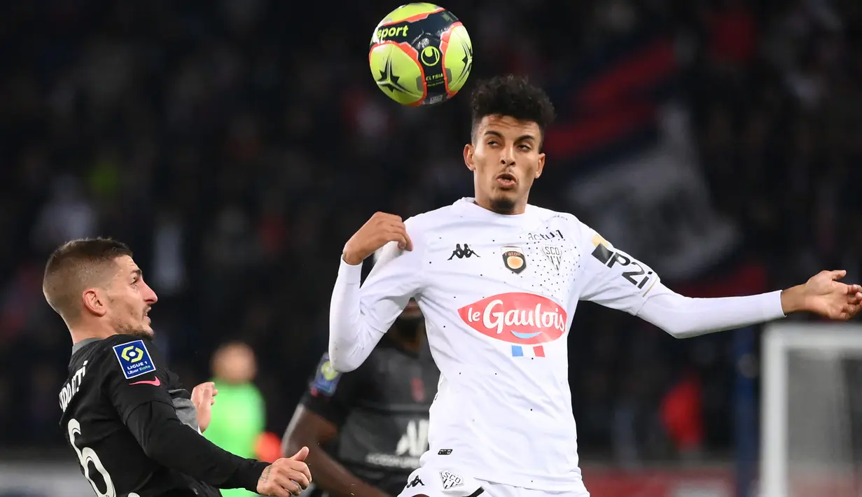 Gelandang Paris Saint-Germain (PSG) Marco Verratti (kiri) berebut bola dengan gelandang Angers Azzedine Ounahi pada pekan ke-10 Ligue 1 Prancis 2021/2022 di Parc des Princes, Sabtu (16/10/2021) dini hari WIB. PSG memastikan kemenangan 2-1 lewat gol penalti Kylian Mbappe. (FRANCK FIFE / AFP)
