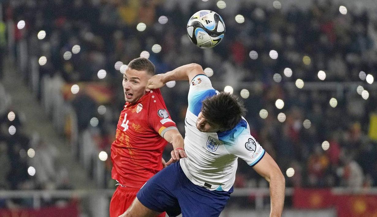 Pemain Inggris, Harry Maguire, duel udara dengan pemain Makedonia Utara, Nikola Serafimov, dalam duel matchday 10 Kualifikasi Euro 2024 Grup C di National Arena Todor Proeski, Selasa (21/11/2023). (AP Photo/Darko Vojinovic)