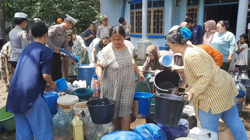 Ratusan kepala keluarga (KK) warga Kebon Kalapa, Desa Mangunreja, Kecamatan Mangunreja, Tasikmalaya ngantri mendapatkan air bersih yang disediakan polisi. (Liputan6.com/Jayadi Supriadin)