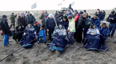 Astronot AS Kate Rubins, kosmonot Rusia Anatoly Ivanishin, dan astronot Jepang Takuya Onishi beristirahat setelah berhasil mendarat di daerah terpencil sekitar 150 km sebelah tenggara dari Dzhezkazgan, Kazakhstan (30/10). (Reuters/Dmitri Lovetsky)