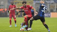 Penyerang Liverpool Mohamed Salah berebut bola dengan pemain Inter Milan Roberto Gagliardini dan Federico Dimarco pada leg pertama babak 16 besar Liga Champions di Stadion Giuseppe Meazza, Kamis dini hari WIB (17/2/2022). Melawat ke markas Inter Milan, Liverpool menang 2-0 (AP Photo/Antonio Calanni)