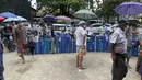 Orang-orang mengantre dengan tabung oksigen mereka di luar stasiun pengisian oksigen di kota Pazundaung di Yangon, Myanmar, Minggu (11/7/2021). Para pejabat mengatakan Myanmar mengalami lonjakan kasus COVID-19, memicu kelangkaan pasokan oksigen yang sangat dibutuhkan pasien. (AP Photo)
