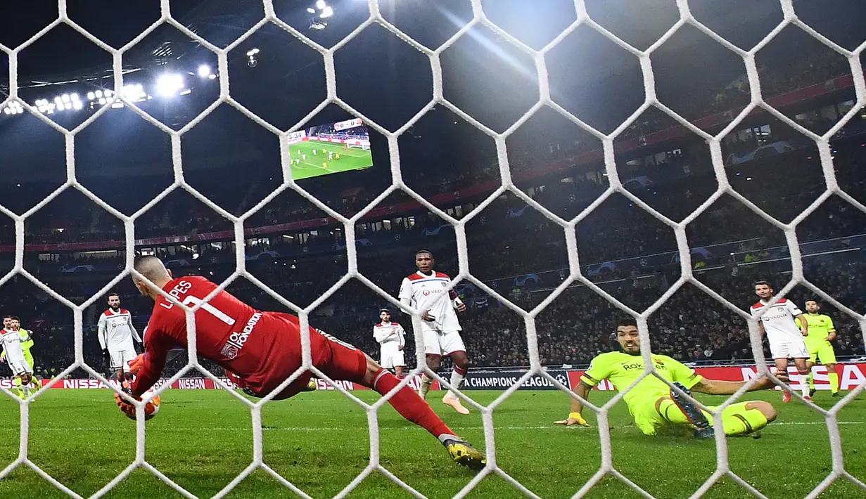 Kiper Lyon Anthony Lopes (kiri) menghalau tendangan penyerang Barcelona Luis Suarez (kanan) saat bertanding pada leg pertama babak 16 besar Liga Champions di Decines, Lyon, Prancis, Selasa (19/2). Laga berakhir 0-0. (FRANCK FIFE/AFP)