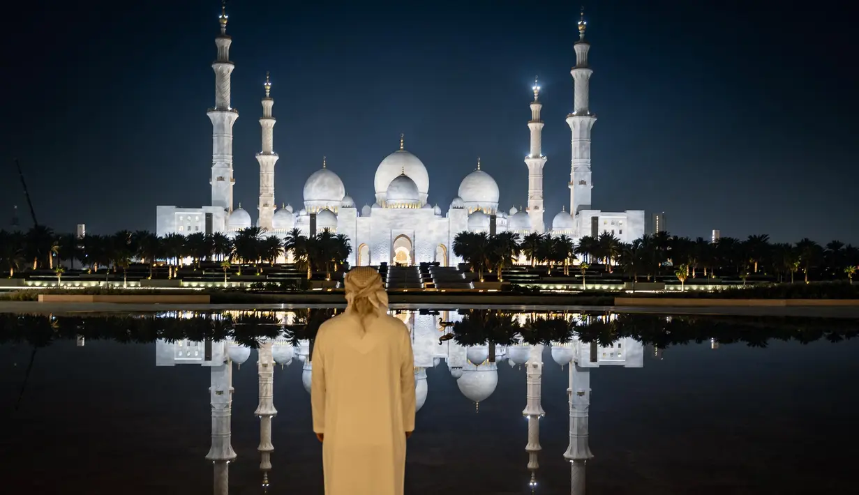 Seorang pria melihat Masjid Agung Sheikh Zayed di Abu Dhabi,  pada tanggal 14 Maret 2025, selama bulan puasa Ramadan. (FADEL SENNA/AFP)