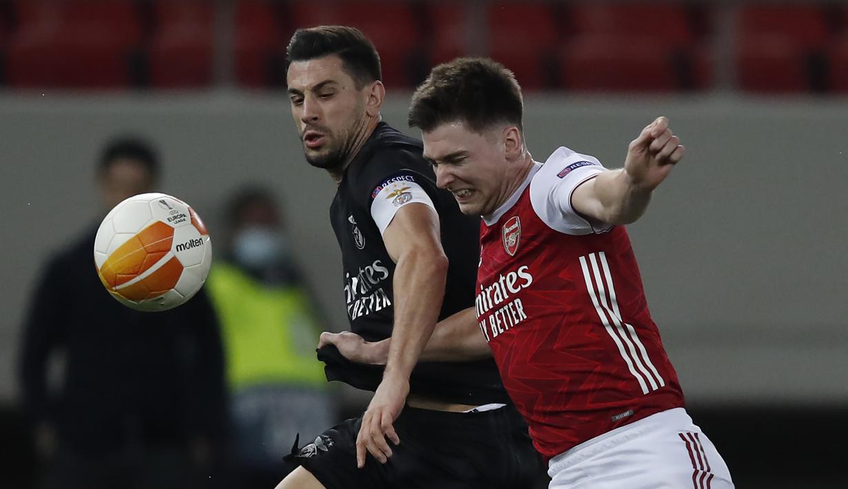 Bek Arsenal, Kieran Tierney (kanan) berebut bola dengan gelandang Benfica, Pizzi dalam laga leg kedua babak 32 Besar Liga Europa 2020/21 di Georgios Karaiskakis Stadium, Kamis (25/2/2021). Arsenal menang 3-2 atas Benfica. (AP/Thanassis Stavrakis)