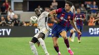 Bek Real Madrid, Ferland Mendy (kiri) berebut bola dengan striker Barcelona, Robert Lewandowski pada laga pramusim Soccer Champions Tour 2023 di AT&T Stadium, Arlington, Texas, Minggu (30/7/2023) dini hari WIB. (AP Photo/Jeffrey McWhorter)