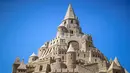 Sebuah istana pasir tertinggi pada kompetisi tahunan "Sand Sculptures Festival" di Binz, Pulau Reugen di Laut Baltik, Jerman pada 5 Juni 2019. Seekor naga dipahat di kaki dan dinding kastil persis seperti di serial film Game of Thrones. (Jens Büttner/dpa/AFP)