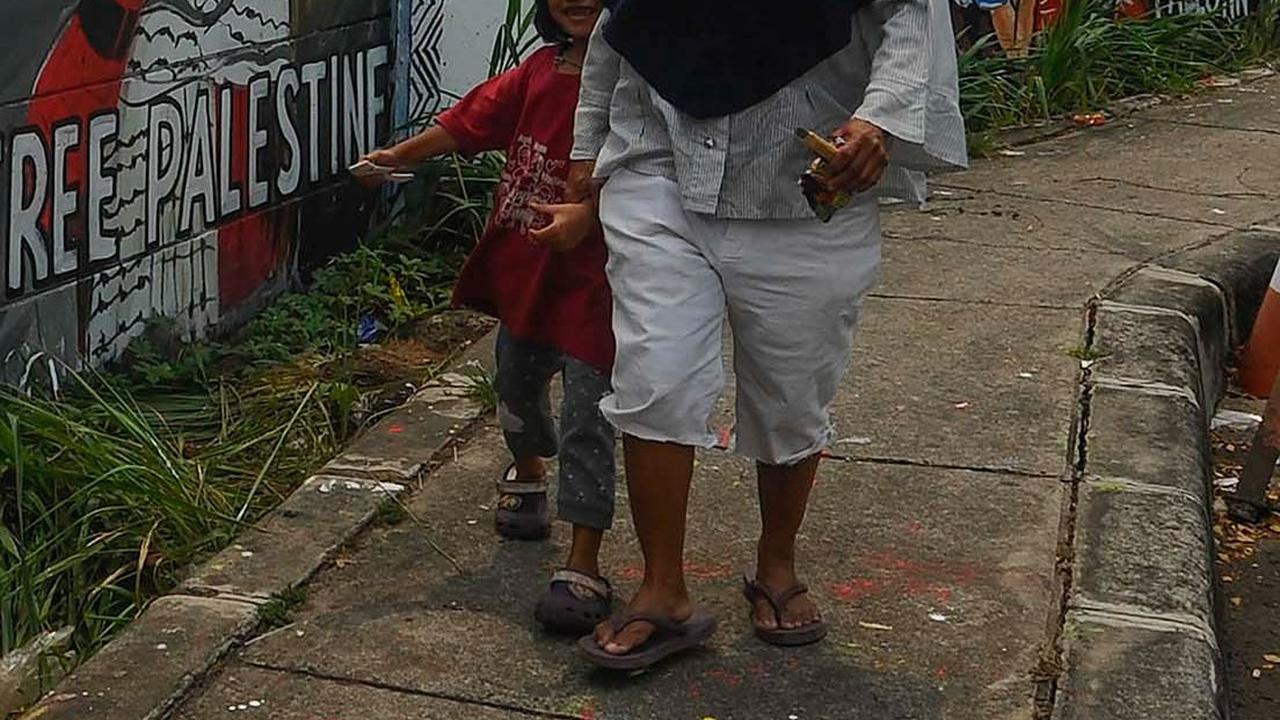 Warga&nbsp;melintas di depan mural dukungan untuk Palestina di Jalan Juanda, Kota Depok, Jawa Barat, pada Rabu (8/11/2023).&nbsp;Merdeka.com/Arie Basuki