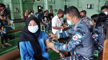 Warga Kabupaten Ende mendapat pelayan vaksinasi Covid -19 diatas perang Republik Indonesia (KRI) Teluk Banten-516. (Liputan6.com/ Dionisius Wilibardus)