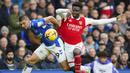 Bek kiri Everton, Vitaliy Mykolenko (kiri) berusaha menghentikan laju sayap kanan Arsenal, Bukayo Saka dalam laga pekan ke-22 Liga Inggris 2022/2023 di Goodison Park, Liverpool, Sabtu (4/2/2023) malam WIB. (AP Photo/Jon Super)