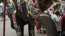 Seekor gajah meminum air setelah dilukis menjelang festival Hindu tahunan Rath Yatra di Ahmedabad, India (3/7/2019). Aktivis hak-hak hewan ingin festival Hindu tahunan Rath Yatra yang melibatkan gajah dihentikan. (AFP Photo/Sam Panthaky)