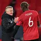 Manajer Manchester United, Ole Gunnar Solskjaer, bersama Paul Pogba, setelah kemenangan telak 6-2 atas AS Roma di leg pertama semifinal Liga Europa, Jumat (30/4/2021) dini hari WIB. (Paul ELLIS / AFP)