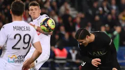 Penyerang Paris Saint-Germain (PSG) Mauro Icardi (kanan) menyundul bola saat pekan ke-10 Ligue 1 Prancis 2021/2022 kontra Angers di Parc des Princes, Sabtu (16/10/2021) dini hari WIB. PSG memastikan kemenangan 2-1 lewat gol penalti Kylian Mbappe. (FRANCK FIFE / AFP)