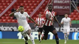 Bek Real Madrid, Eder Militao berebut bola dengan penyerang  Athletic Bilbao, Inaki Williams pada pekan ke-37 La Liga di San Mames, Minggu (15/5/2021). Real Madrid berhasil menang di laga sulit yang berlangsung di markas Bilbao dengan skor tipis 1-0. (AP Photo/Alvaro Barrientos)