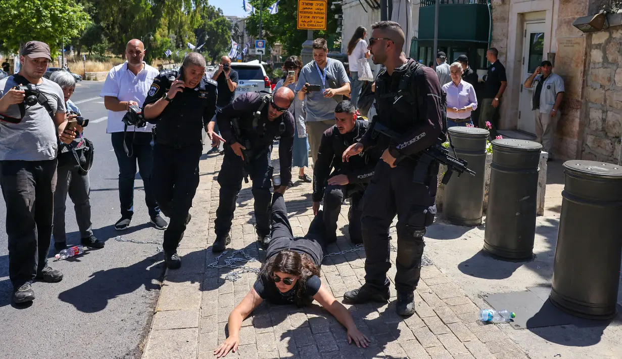 Pasukan keamanan menarik paksa salah satu aktivis sayap kiri Israel saat membubarkan aksi unjuk rasa. (AHMAD GHARABLI/AFP)