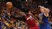 Center Miami Heat, Bam Adebayo, mendapatkan pengawalan ketat dari Center Denver Nuggets, Nikola Jokic, pada laga final NBA Game 1 yang berlangsung di Ball Arena, Denver, Jumat (2/6/2023) pagi WIB. (Getty Images via AFP/Matthew Stockman)