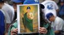 Seorang fans memegang poster bergambar pitcher Los Angeles Dodgers, Shohei Ohtani saat parade kemenangan 2025 World Series Championship di Los Angeles, California, Senin (03/11/2025) waktu setempat. (AP Photo/Jae C. Hong)