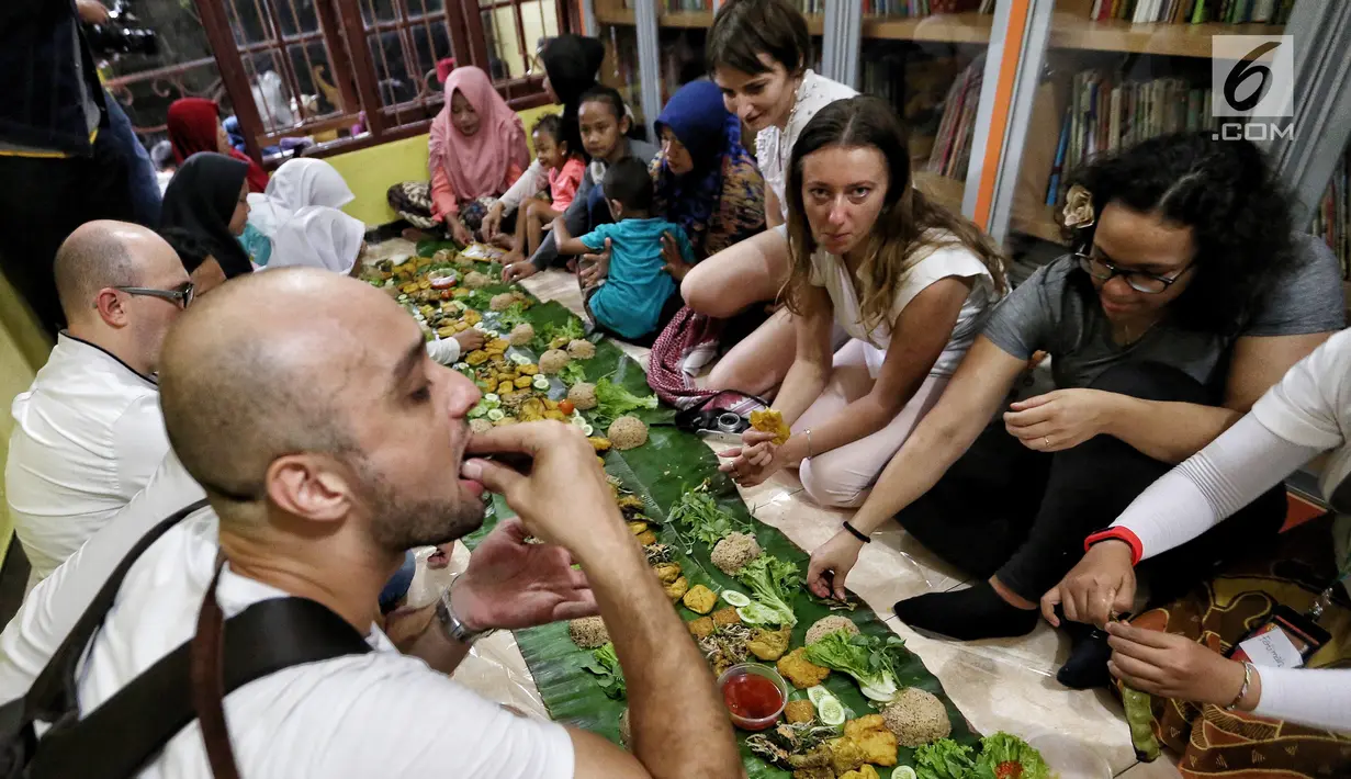 Sejumlah anak yatim, kaum dhuafa serta lima warga negara asing (WNA) menikmati nasi liwet sambil lesehan di Rumah Amalia, Ciledug, Kota Tangerang, Sabtu (3/3). Mereka berbaur menikmati makanan yang disajikan dengan daun pisang. (Liputan6.com/Fery Pradolo)