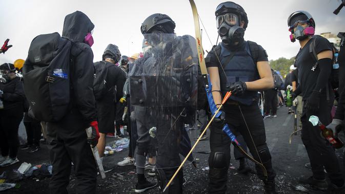Seorang mahasiswa menggunakan panahan saat demonstrasi di Hong Kong (13/11/2019). Gerakan antipemerintah Hong Kong yang telah berlangsung selama lima bulan bertindak semakin keras. (AP Photo/Kin Cheung)