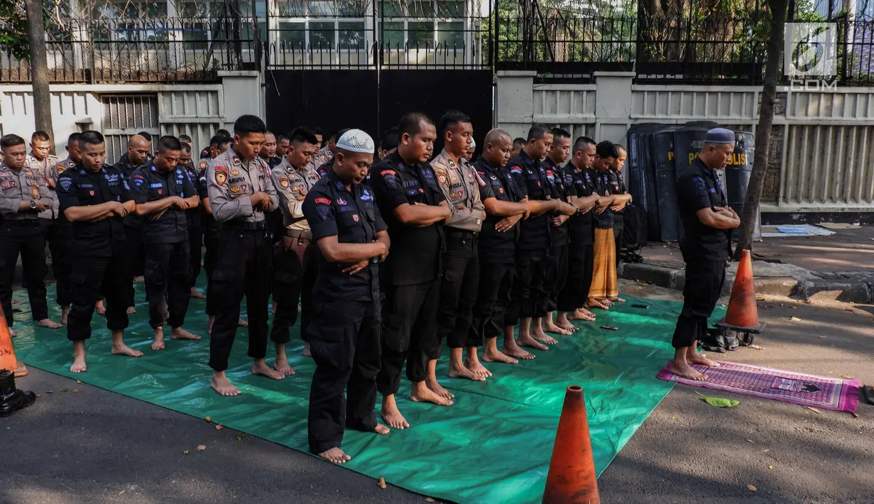 Pasukan Brimob menunaikan ibadah salat Ashar berjamaah disela pengamanan di kawasan Bundaran HI, Jakarta, Rabu (29/5/2019). Di tengah tugas mengamankan situasi, para anggota Brimob tak lupa untuk tetap menjalankan kewajibannya sebagai umat beragama. (Liputan6.com/Faizal Fanani)