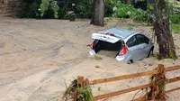 Sebuah mobil dipenuhi pasir usai tersapu banjir bandang yang melanda Ellicott City, Maryland, Amerika Serikat, Senin (28/5). (AP Photo/David McFadden)