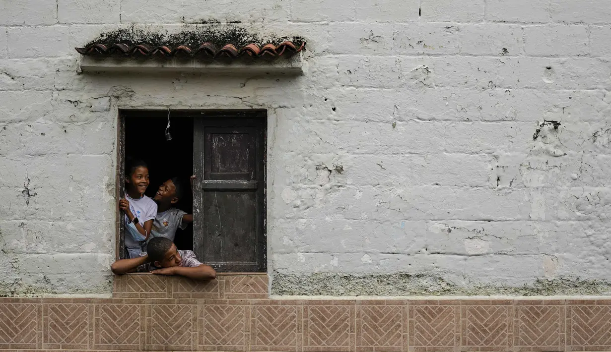 Anak-anak menyaksikan perayaan Hari Orang Suci yang Tak Bersalah di Caucagua, Venezuela, Selasa (28/12/2021). Tradisi berusia lebih dari 200 tahun adalah hari nyanyian, tarian, dan lelucon. (AP Photo/Matias Delacroix)