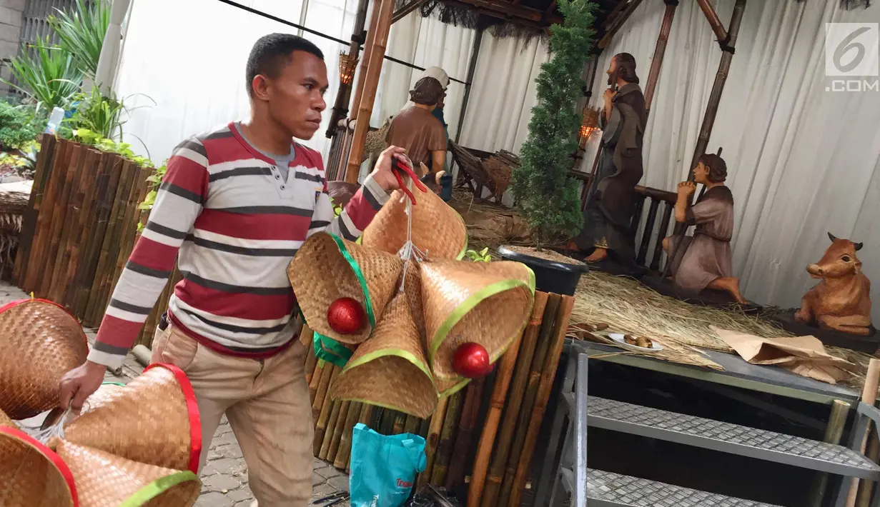 Pekerja membawa dekorasi Natal di tenda Gereja Katedral, Jakarta, Selasa (19/12). Persiapan seperti perawatan interior-eksterior gereja serta pemasangan dekorasi mulai dilakukan pihak gereja untuk menyambut Hari Natal. (Liputan6.com/Immanuel Antonius)