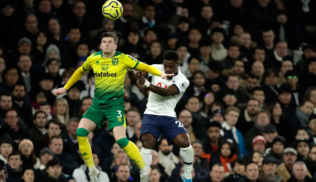 Bek Tottenham Hotspur, Serge Aurier melompat saat berebut bola dengan pemain Norwich City, Sam Bryam pada pekan ke-24 Liga Inggris di Tottenham Hotspur Stadium, London, Rabu (22/1/2020). Bermain di kandang sendiri, Tottenham Hotspur harus susah payah menaklukkan Norwich City 2-1. (AP/Matt Dunham)