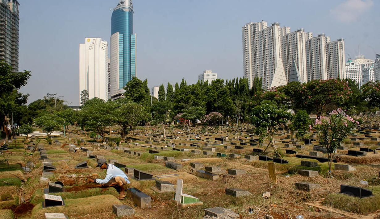 Pekerja tengah membersihkan area makam di TPU Karet Bivak, Jakarta, Kamis (2/10/14). (Liputan6.Com/Faizal Fanani)