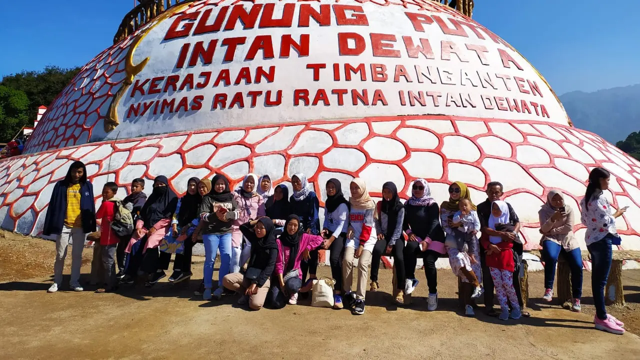 Deretan pengunjung tengah berfoto bersama di depan tugu Bukit Intan Dewata di Kawasan wisata Kaki Gunung Putri Garut, Jawa Barat.Sambil