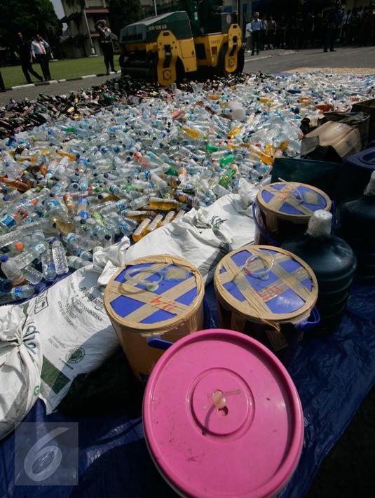 Petugas mengoperasikan alat berat untuk memusnahkan ribuan botol minuman keras (miras) di halaman Mapolda DIY, Senin (6/6). Semua barang bukti yang dimusnahkan petugas merupakan hasil Operasi Pekat yang digelar sebelum Ramadan. (Liputan6.com/Boy Harjanto)