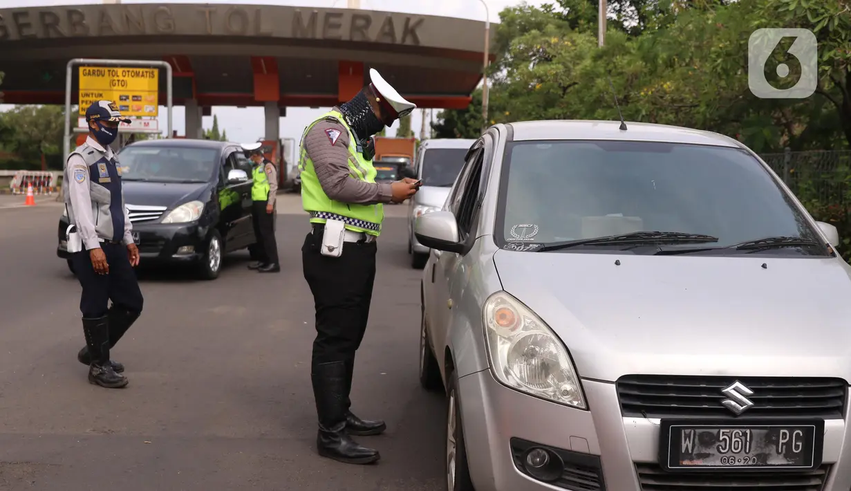 Petugas kepolisian melakukan pengecekan terhadap kendaraan yang keluar Tol Merak, Banten, Senin (18/5/2020). Pemeriksaan (check point) tersebut terkait larangan mudik guna penyekatan atau memeriksa kemungkinan pemudik yang akan keluar dari wilayah Jabodetabek. (Liputan6.com/Angga Yuniar)