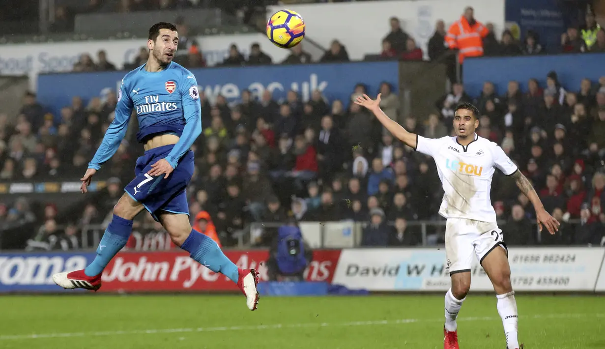 Aksi pemain Arsenal, Henrikh Mkhitaryan menyundul bola saat melawan Swansea City pada lanjutan Premier League di Liberty Stadium, Swansea, Wales, (30/1/2018). Arsenal kalah 1-3. (Nick Potts/PA via AP)