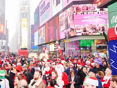 Orang-orang yang berpakaian seperti Sinterklas berkumpul untuk acara tahunan Santacon di Father Duffy Square, New York City, Sabtu (14/12/2019). Santacon terjadi secara tradisional di hari Sabtu kedua tiap Desember. (Gabby Jones/Getty Images/AFP)