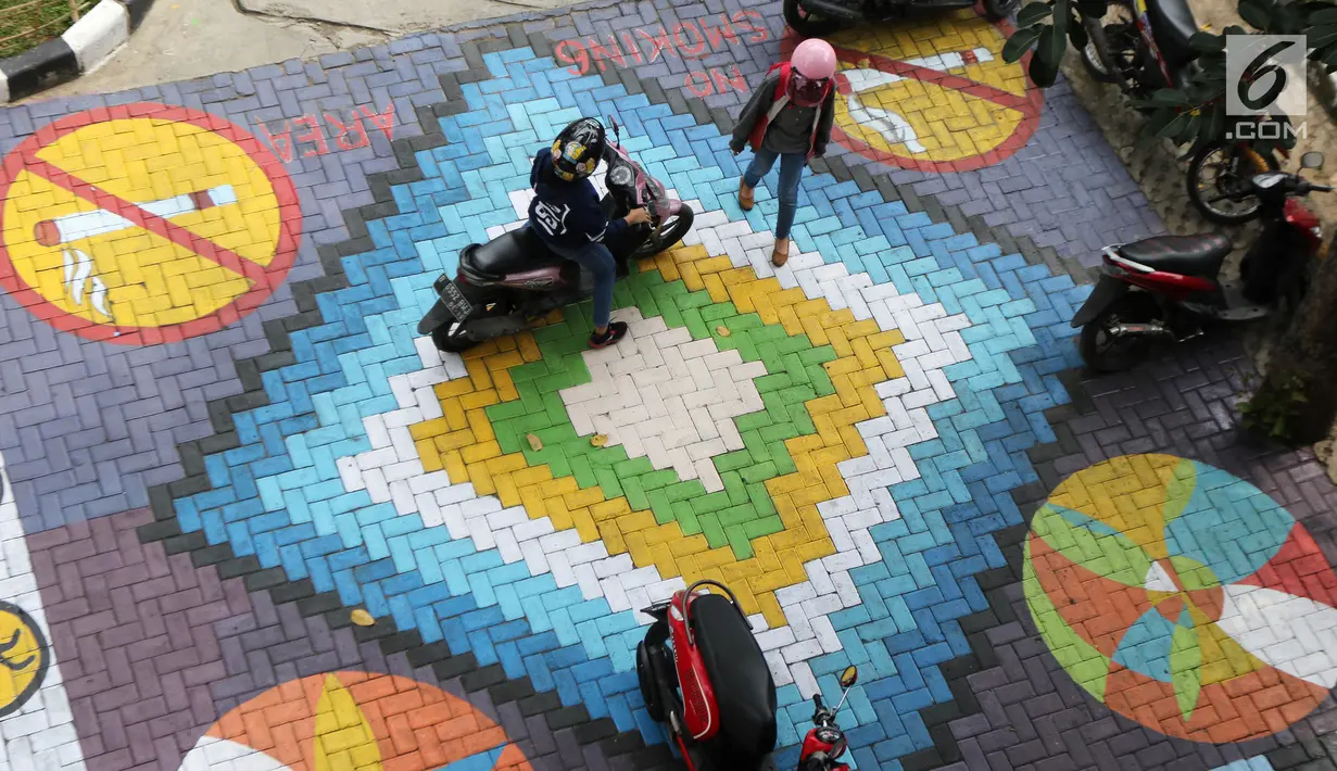 Pengendara melintasi mural yang menghiasi halaman depan Kantor Kelurahan Tegal Alur, Jakarta Barat, Rabu (18/4). Mural tersebut dibuat oleh petugas Penanganan Prasarana dan Sarana Umum (PPSU). (Liputan6.com/Arya Manggala)
