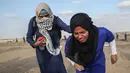 Wanita Palestina berlari saat pasukan Israel menembakkan gas air mata dalam bentrok di Khan Yunis, Jalur Gaza, Jumat (13/9/2019). Aksi yang dikenal dengan Great March of Return ini diluncurkan sejak Maret 2018. (SAID KHATIB/AFP)