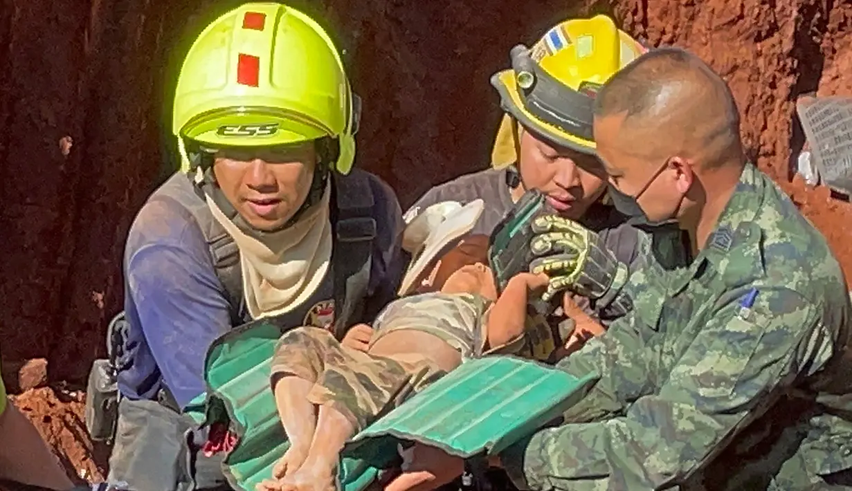 Setelah operasi darurat semalam, petugas penyelamat dan militer membawa seorang anak berusia 1 tahun dari lubang yang dalam di Provinsi Tak, Thailand, Selasa (7/2/2023). Balita asal Myanmar itu jatuh ke lubang sedalam 15 meter yang digunakan untuk pipa air tanah kemarin malam. (AP Photo/Chiravuth Rungjamratratsami)