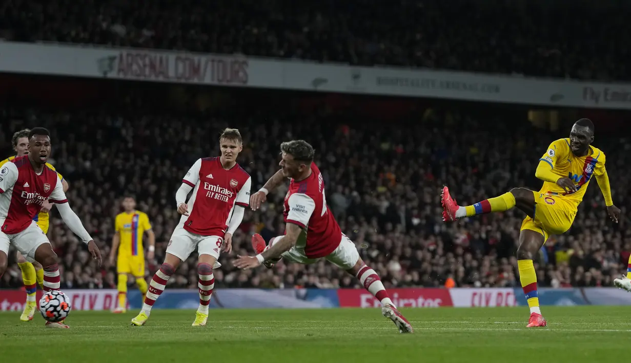 Penyerang Crystal Palace, Christian Benteke menembak ke gawang Arsenal pada pertandingan lanjutan Liga Inggris di Stadion Emirates, London, Selasa (19/10/2021). Arsenal bermain imbang atas Crystal Palace 2-2. (AP Photo/Alastair Grant)