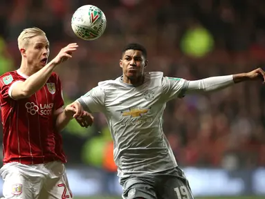 Pemain Bristol City, Hordur Bjorgvin Magnusson berebut bola dengan pemain Manchester United, Marcus Rashford pada perempat final Piala Liga Inggris di Ashton Gate, Kamis (21/12). MU gagal ke babak empat besar setelah kalah 1-2. (Nick Potts/PA via AP)